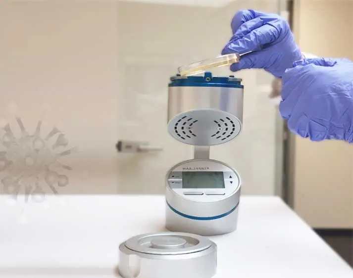 Hand in Gummihandschuh bedient Gerät zur Luftkeimmessung