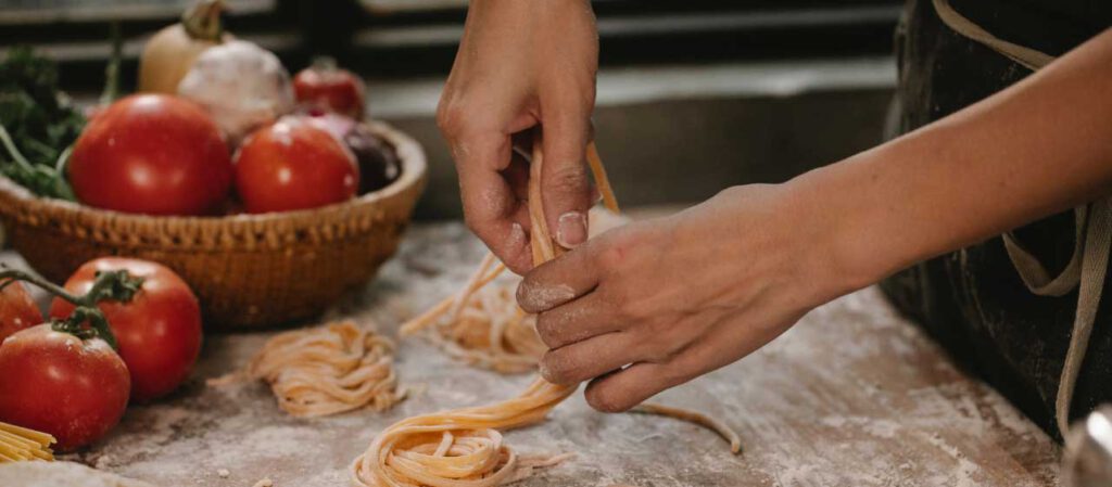 Hände bereiten Pasta zu