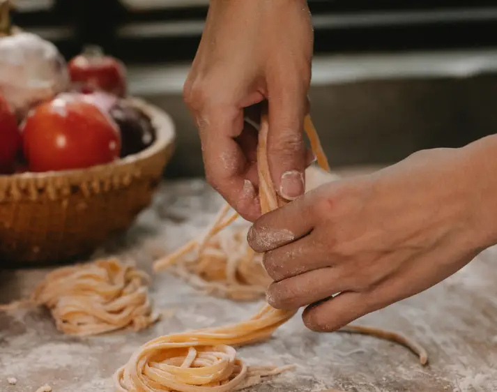 Hände bereiten Pasta zu