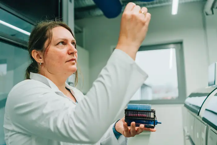 Eine Frau h&auml;lt Probe hoch zur Kontrolle