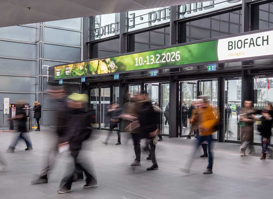 Menschen unterwegs in Halle vor unter Schild von Biofachmesse 2026