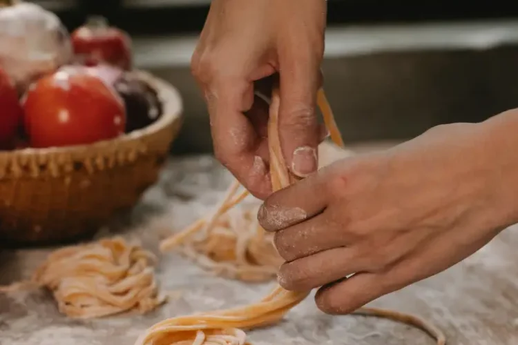 Hände bereiten Pasta zu